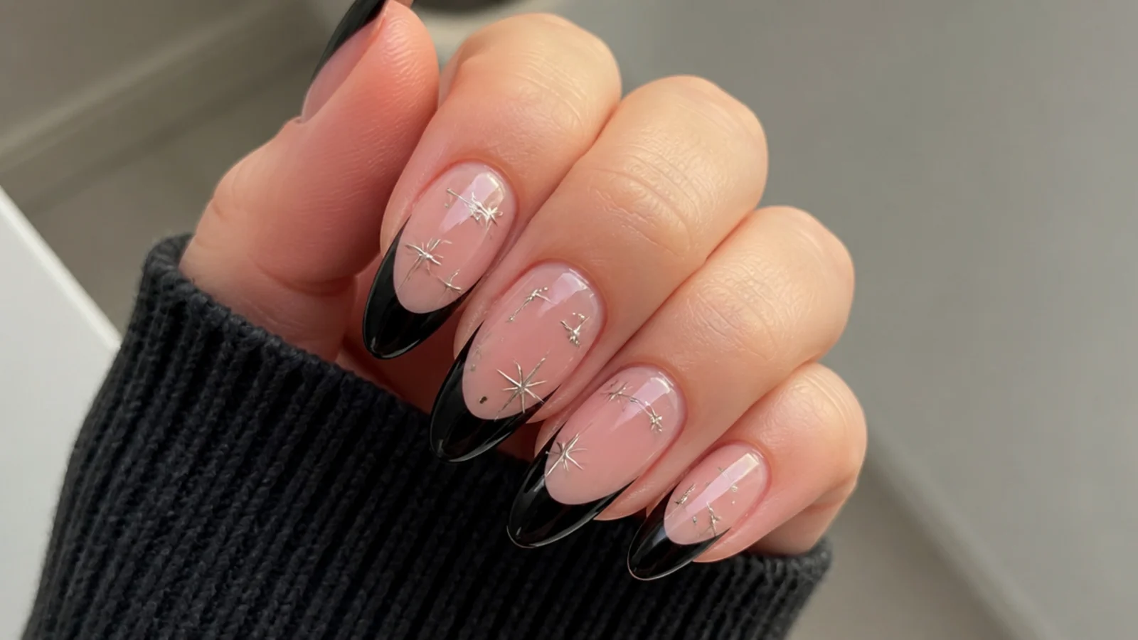 Nude emo nails with black tips and small silver star accents