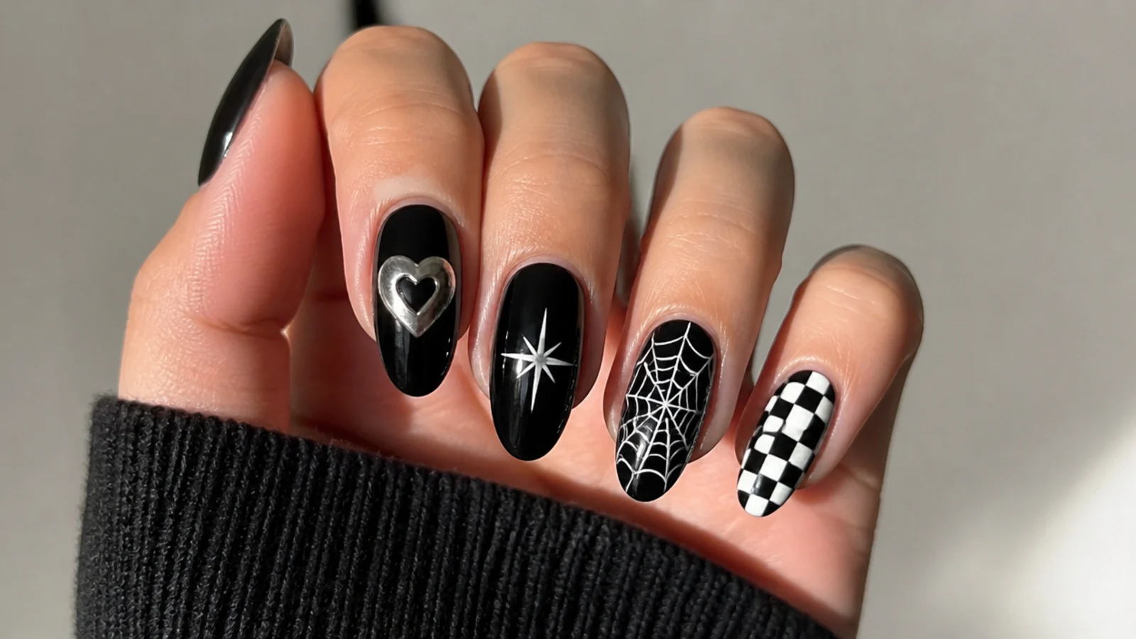 Black emo nails each with a different motif - heart, star, web and checkerboard