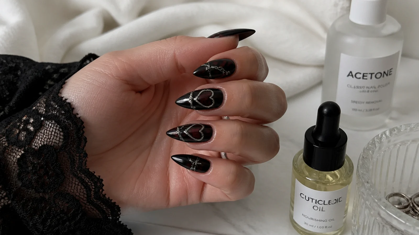 A well-sealed black emo manicure with cuticle oil and acetone for removal