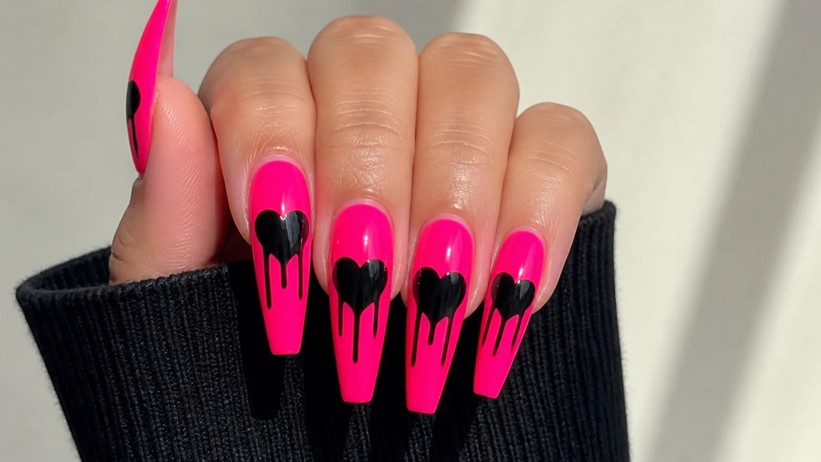 Black hearts with paint drips on a hot pink acrylic base
