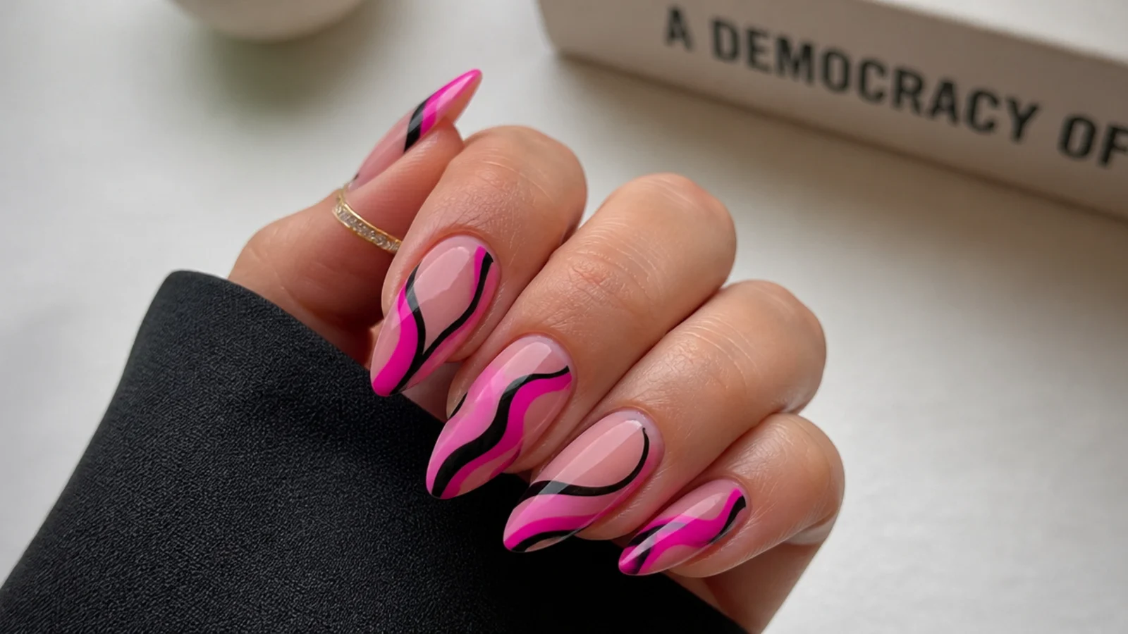 Hot pink and black abstract swirls on almond acrylic nails