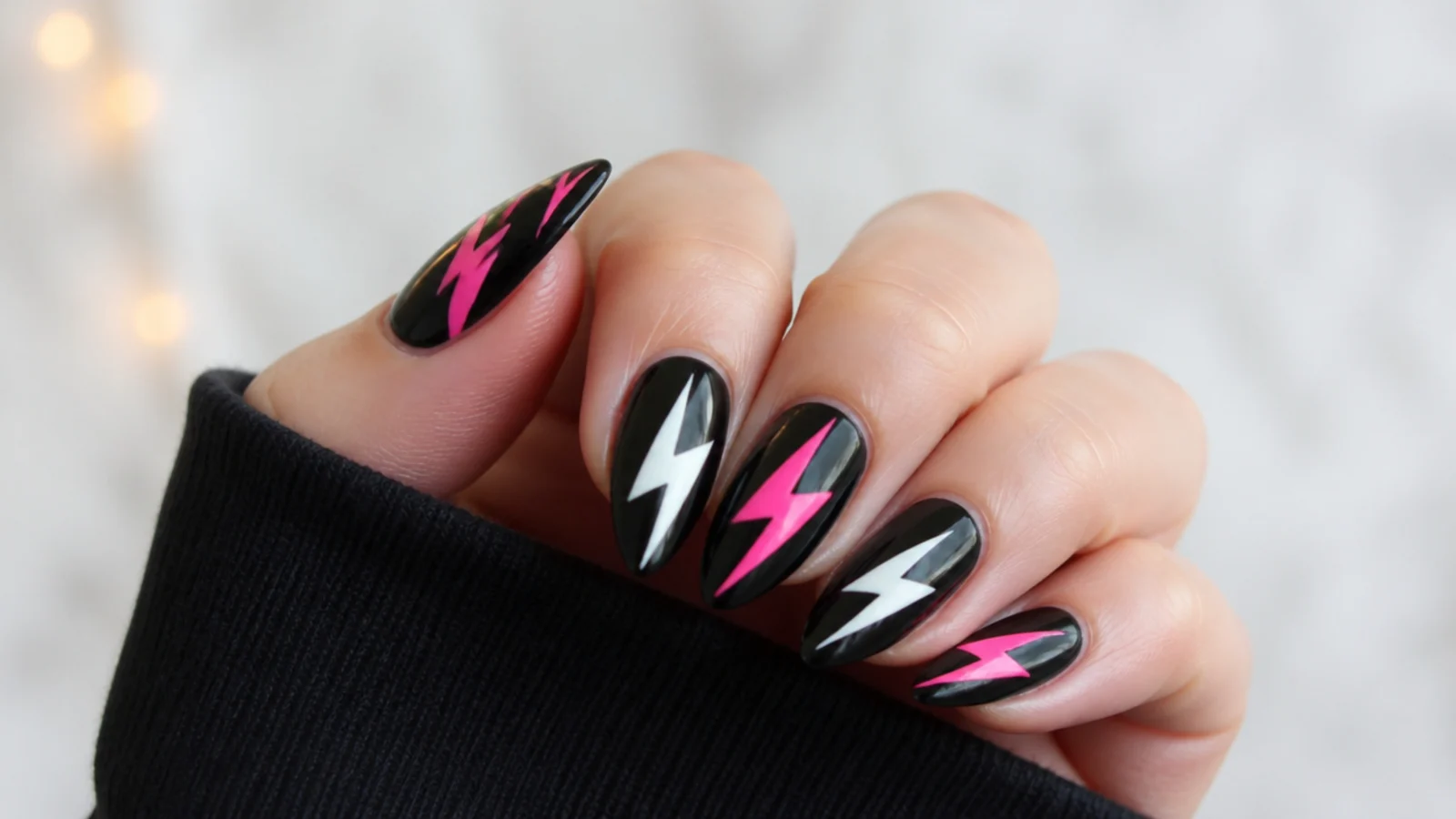 Hot pink and white lightning bolts on black acrylic nails