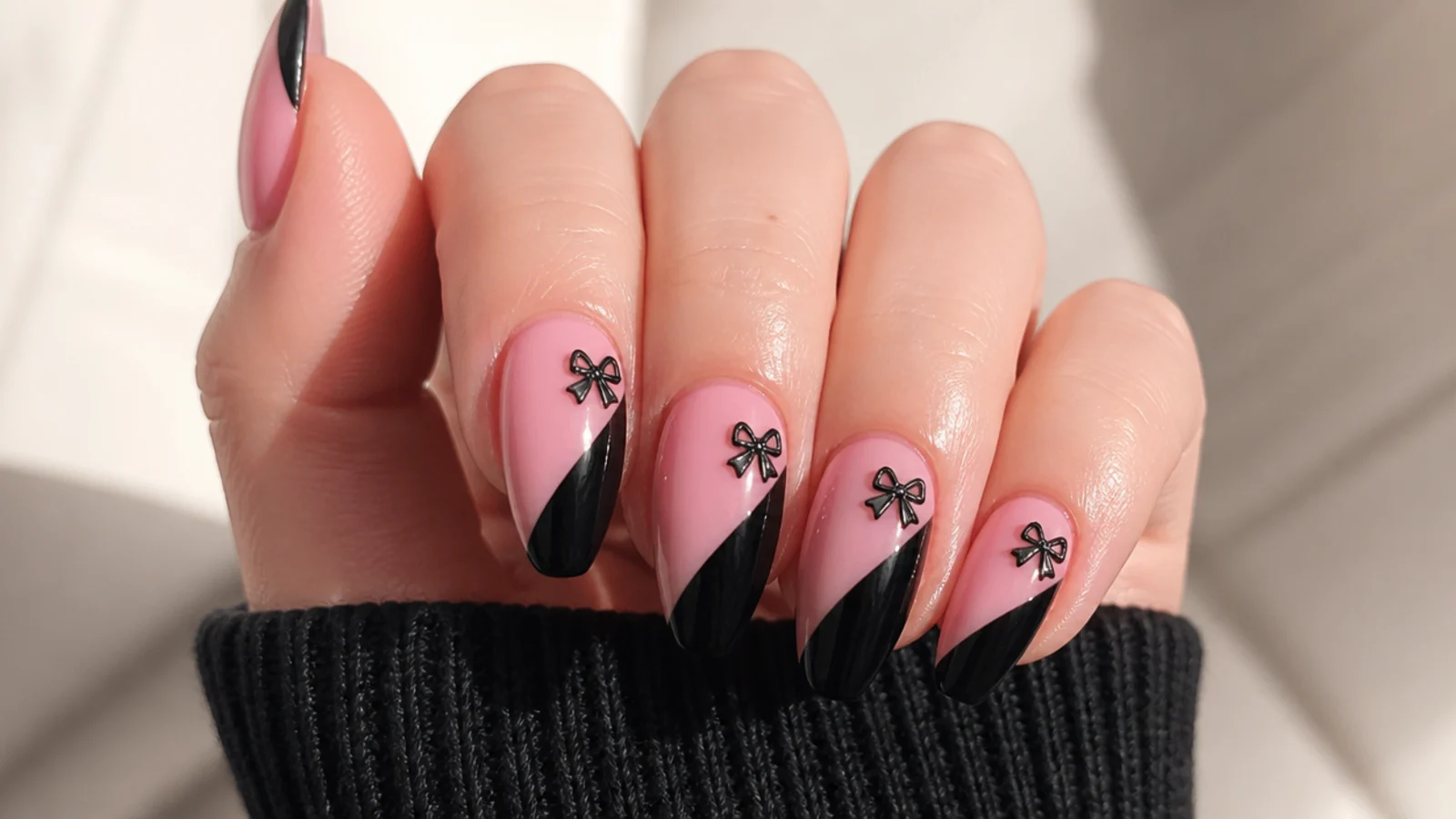 Emo Christmas nails split diagonally pink and black with a small black coquette bow