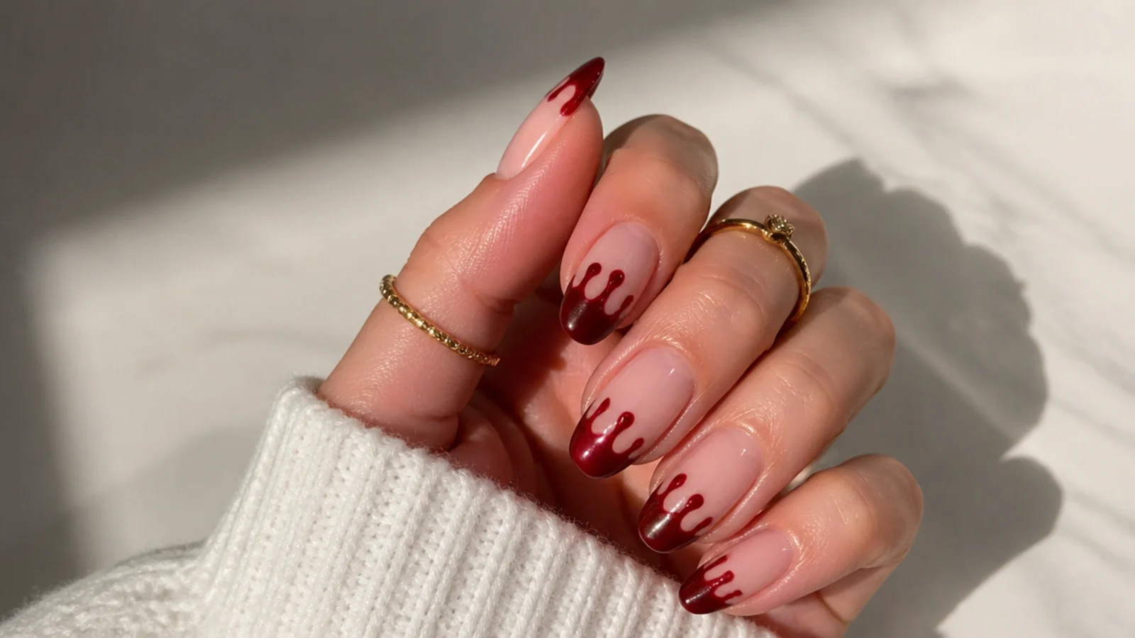 Nude emo Christmas nails with red French tips dripping down like paint over a pale base