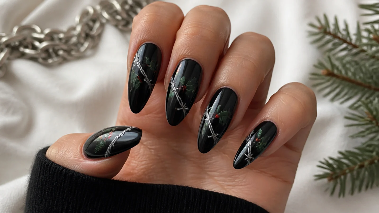 Black emo nails with thin silver barbed wire wrapping the nail and small green holly leaves