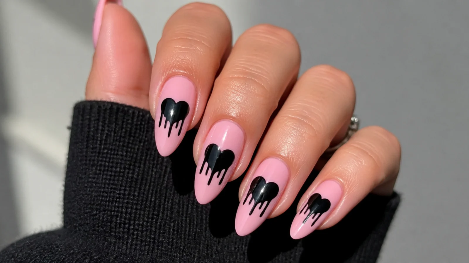 Pink emo nails with melting black dripping heart shapes