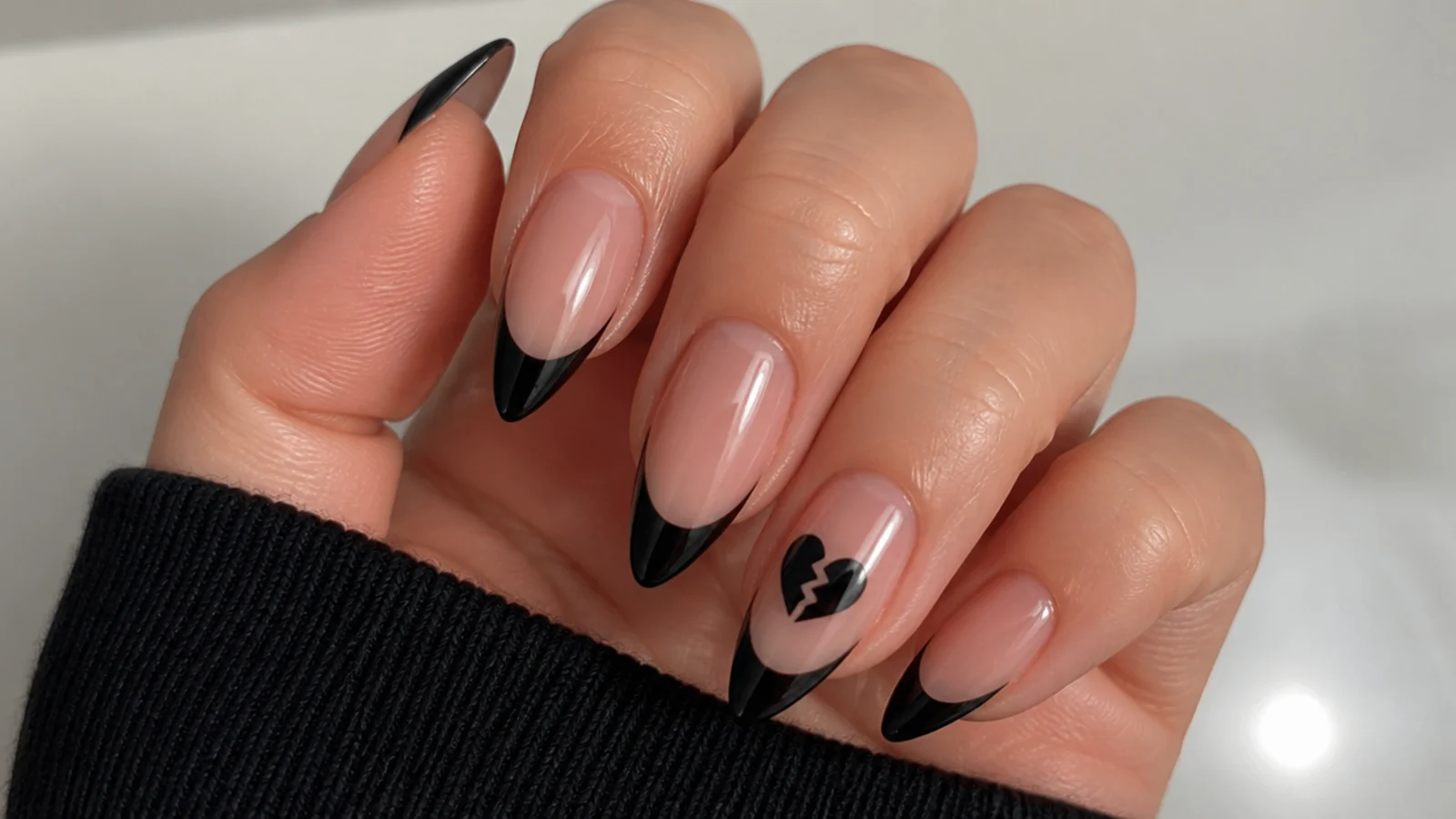 Black French tip emo nails with a cracked broken heart accent