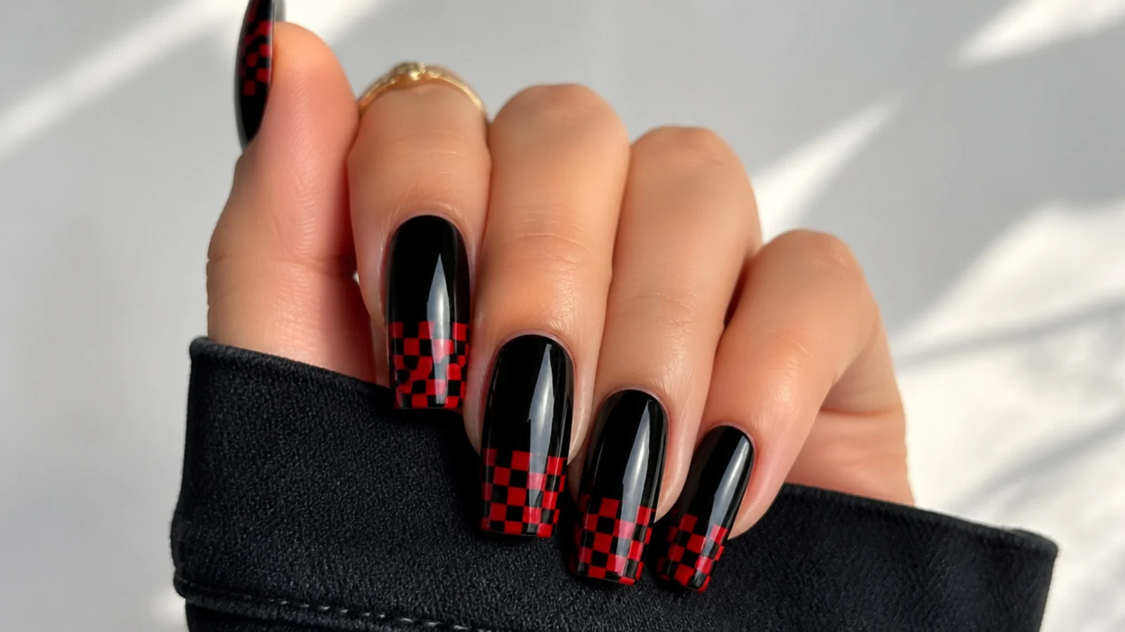 Black nails with red and black checkerboard tips on coffin shape