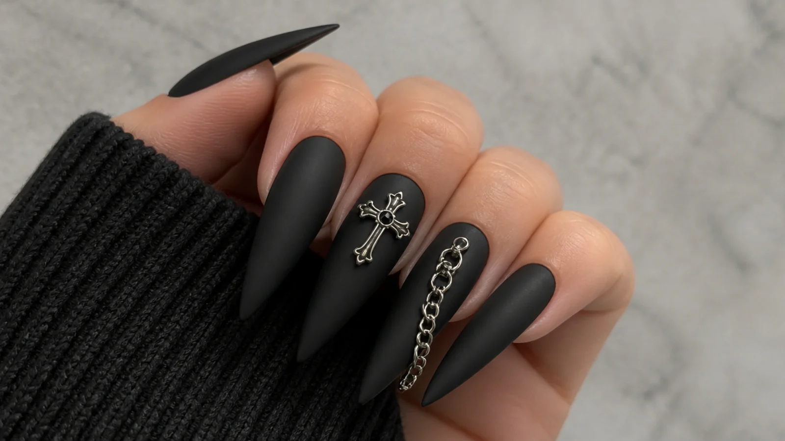 Matte black emo nails with silver cross charm and chain detail
