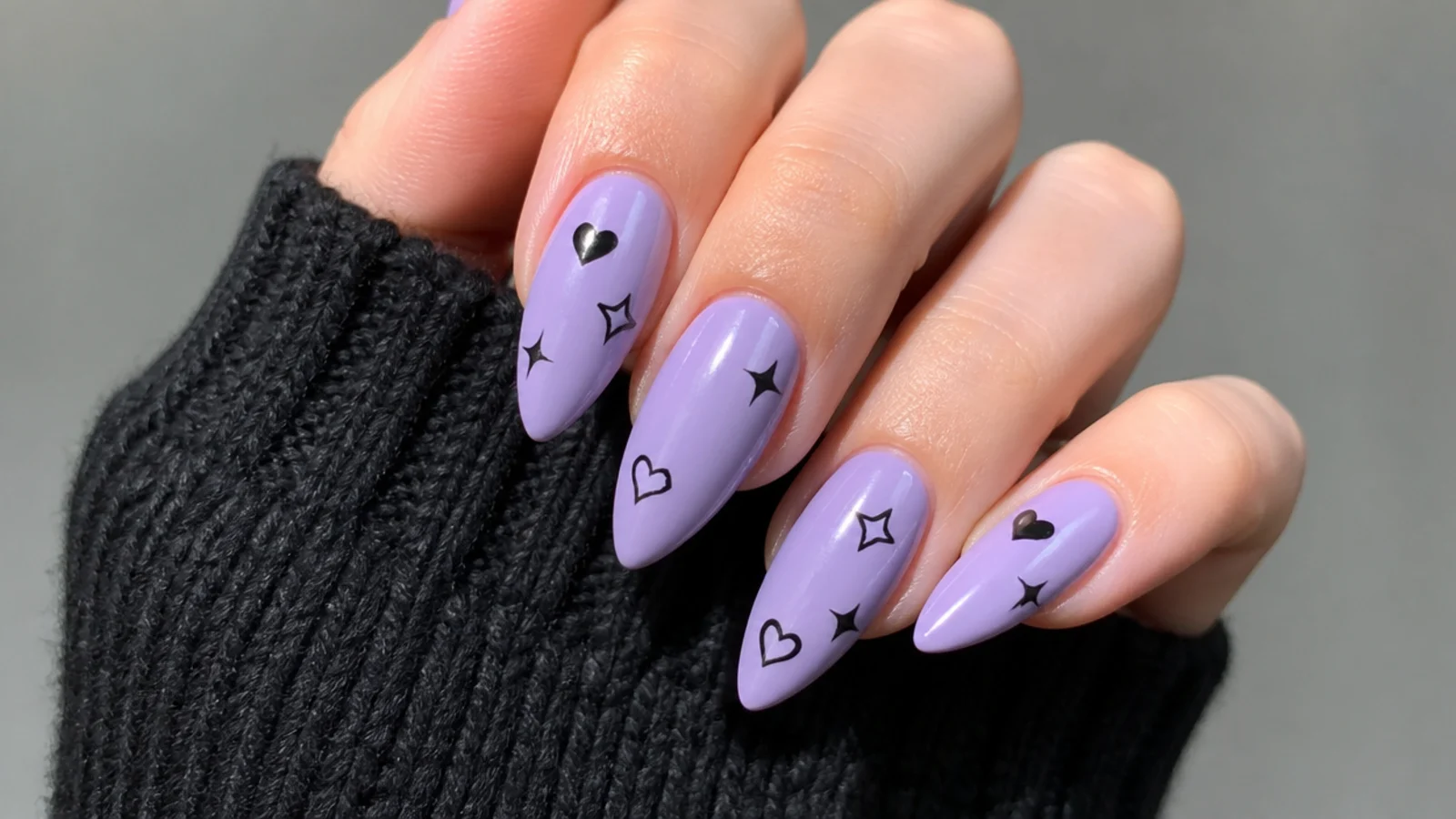 Soft lilac emo nails with small black hearts and stars