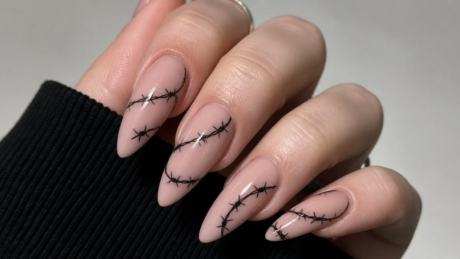 Nude emo nails with fine black barbed wire wrapped across