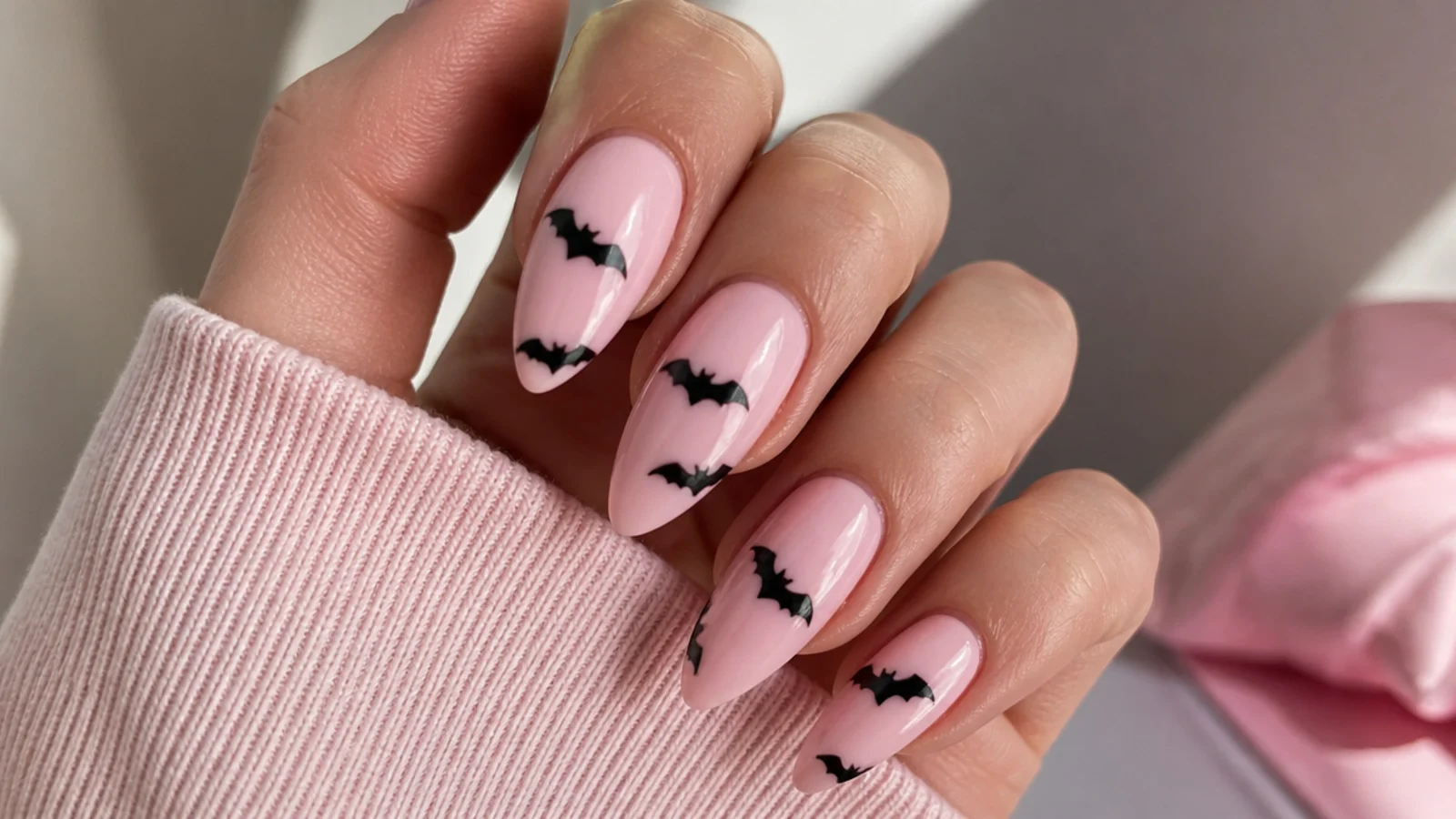 Baby pink emo nails with small black bat silhouettes
