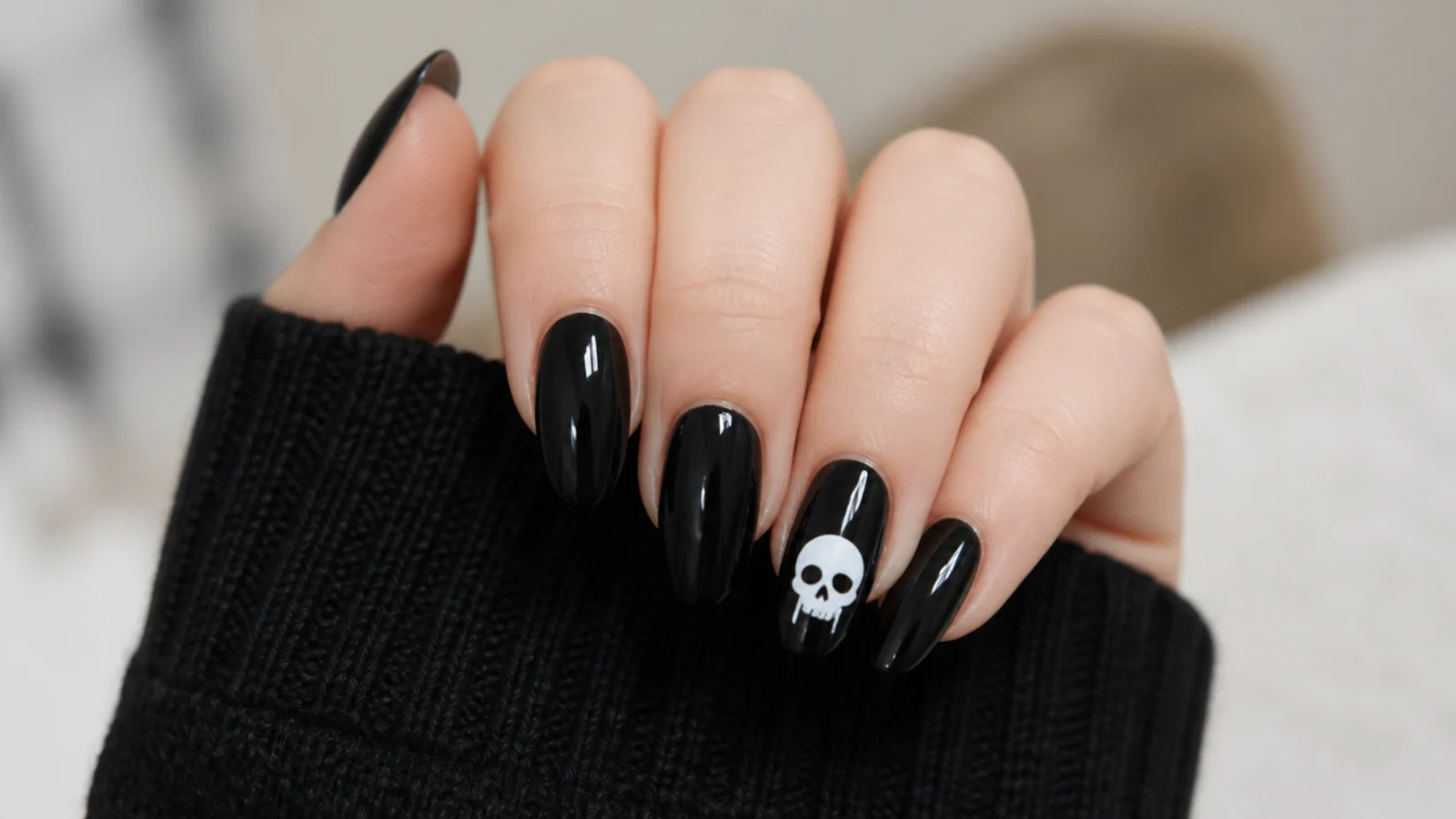 Black emo nails with a small white skull on one accent nail