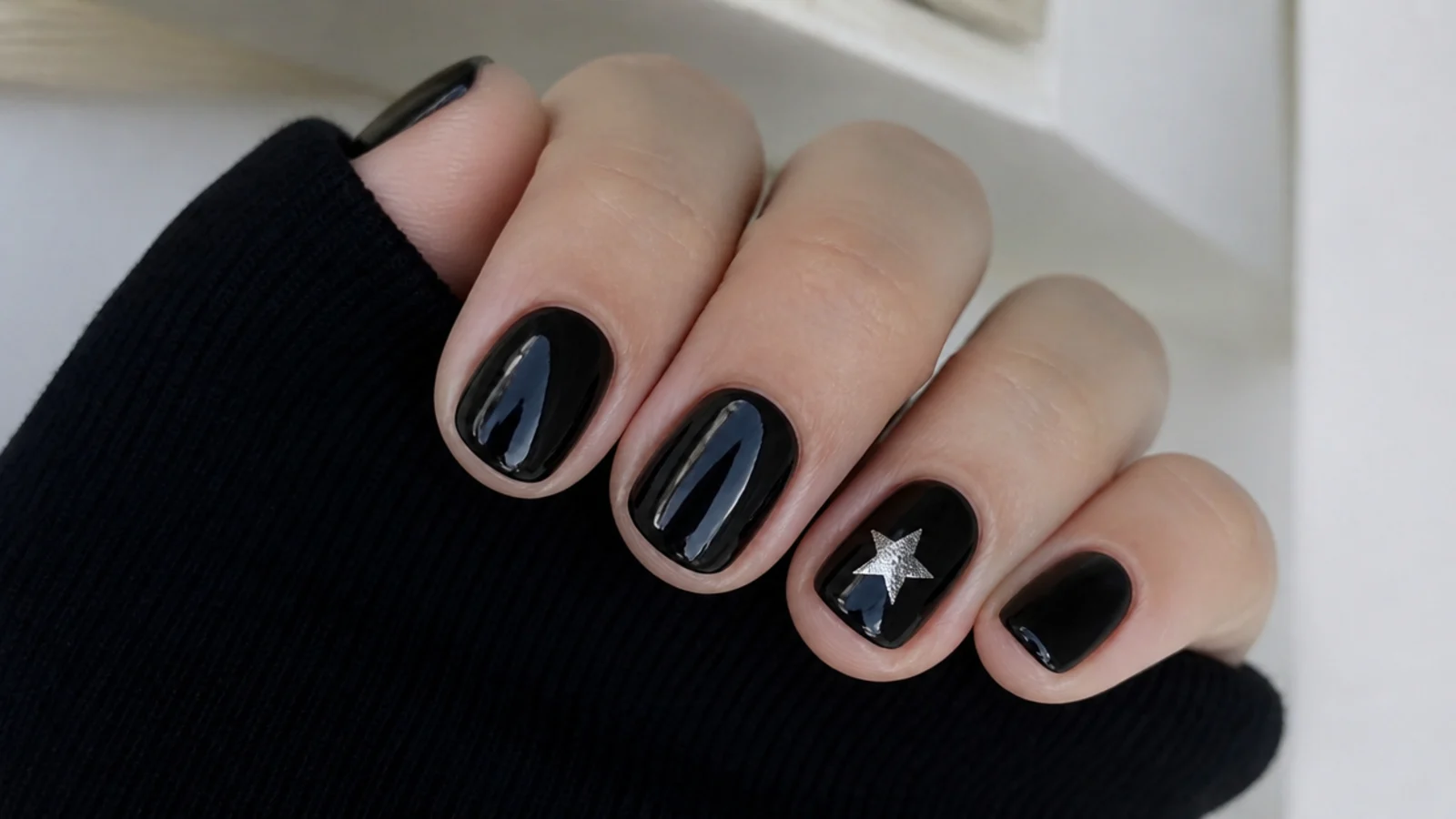 Short round black emo nails with one silver star accent