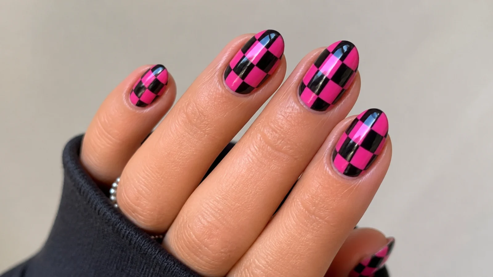 Black and hot pink checkerboard emo Y2K nails on a short almond shape