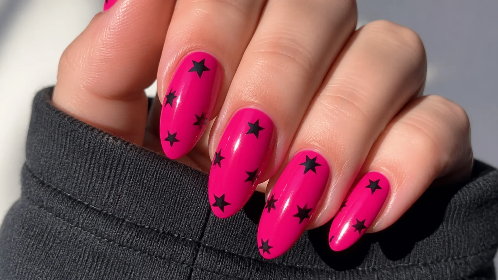Hot pink nails with small black five-point stars scattered, emo Y2K