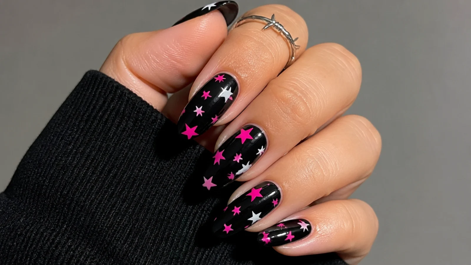 Black nails with hot pink and white stars scattered, emo Y2K style