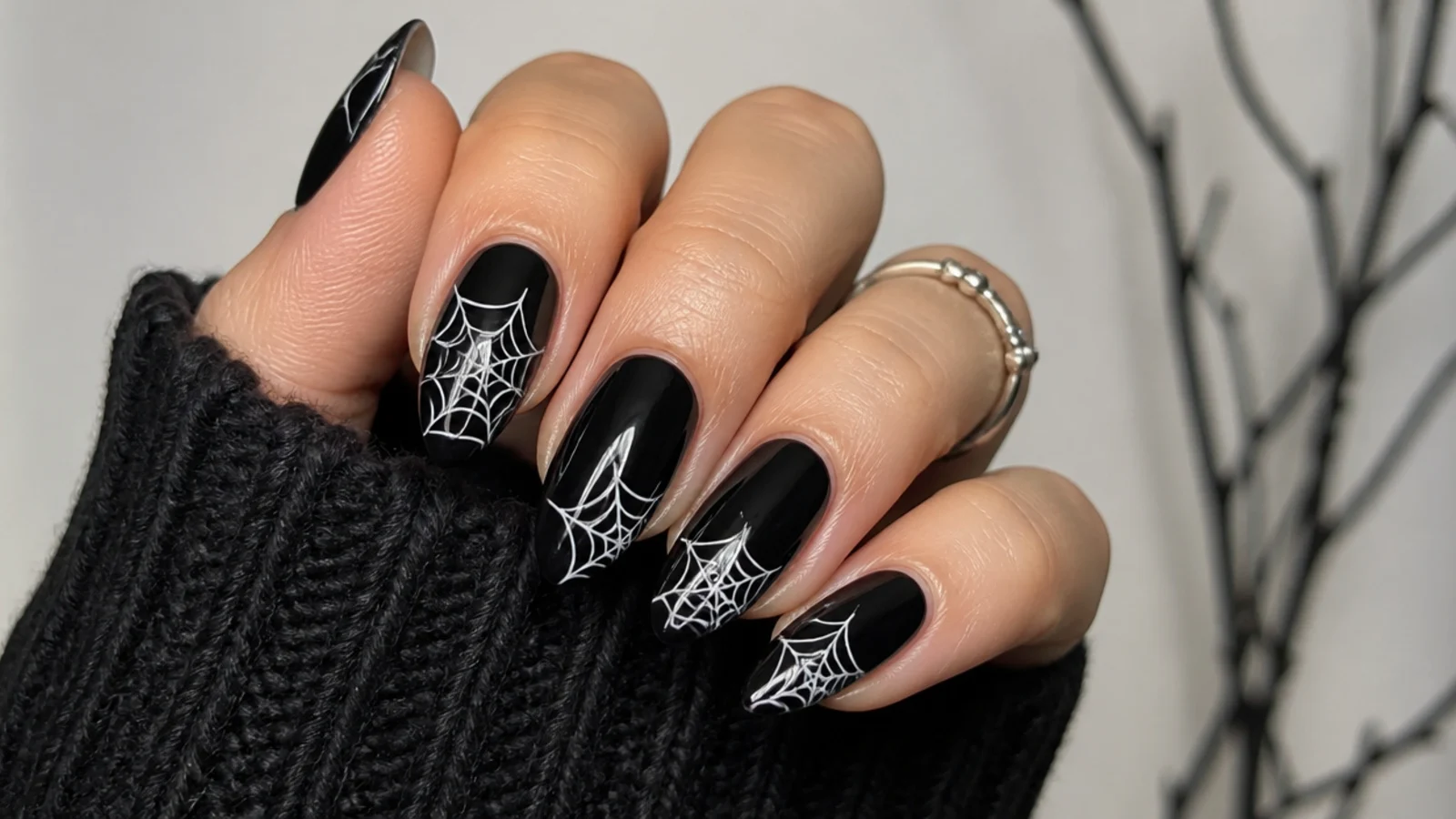 Black nails with white spiderweb painted from the corner, emo Y2K