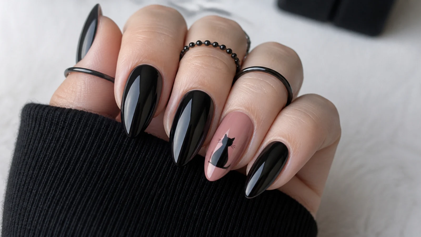 Emo nails with a small black cat silhouette on a pink accent nail