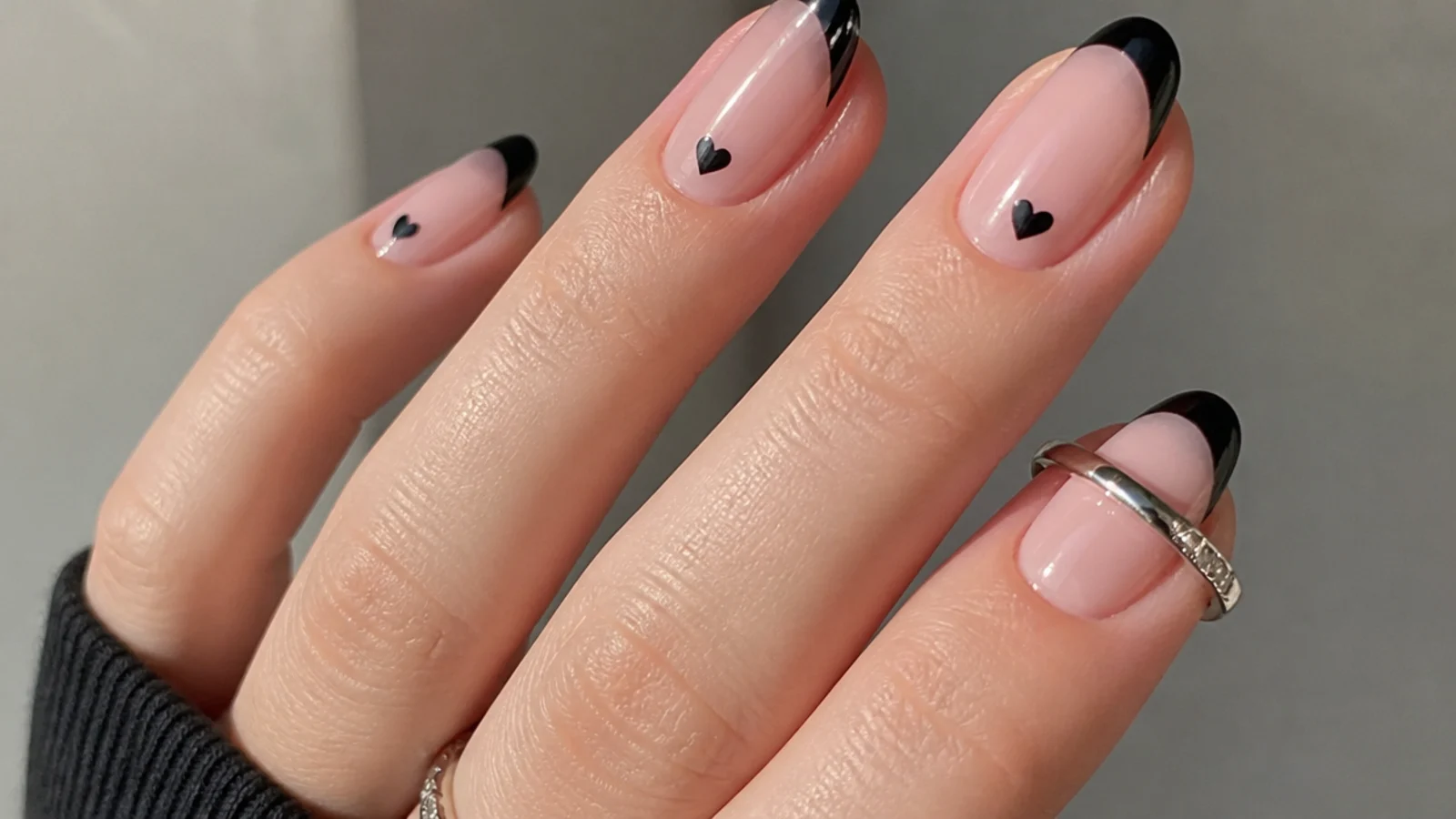 Pink nails with black French tips and tiny heart accents, emo Y2K