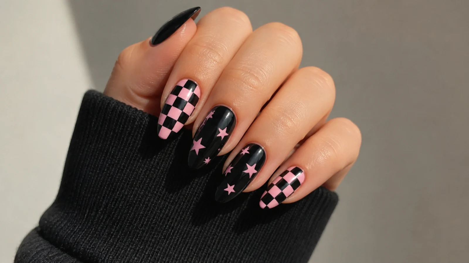 Emo nails mixing pink checkerboard with black star accent nails
