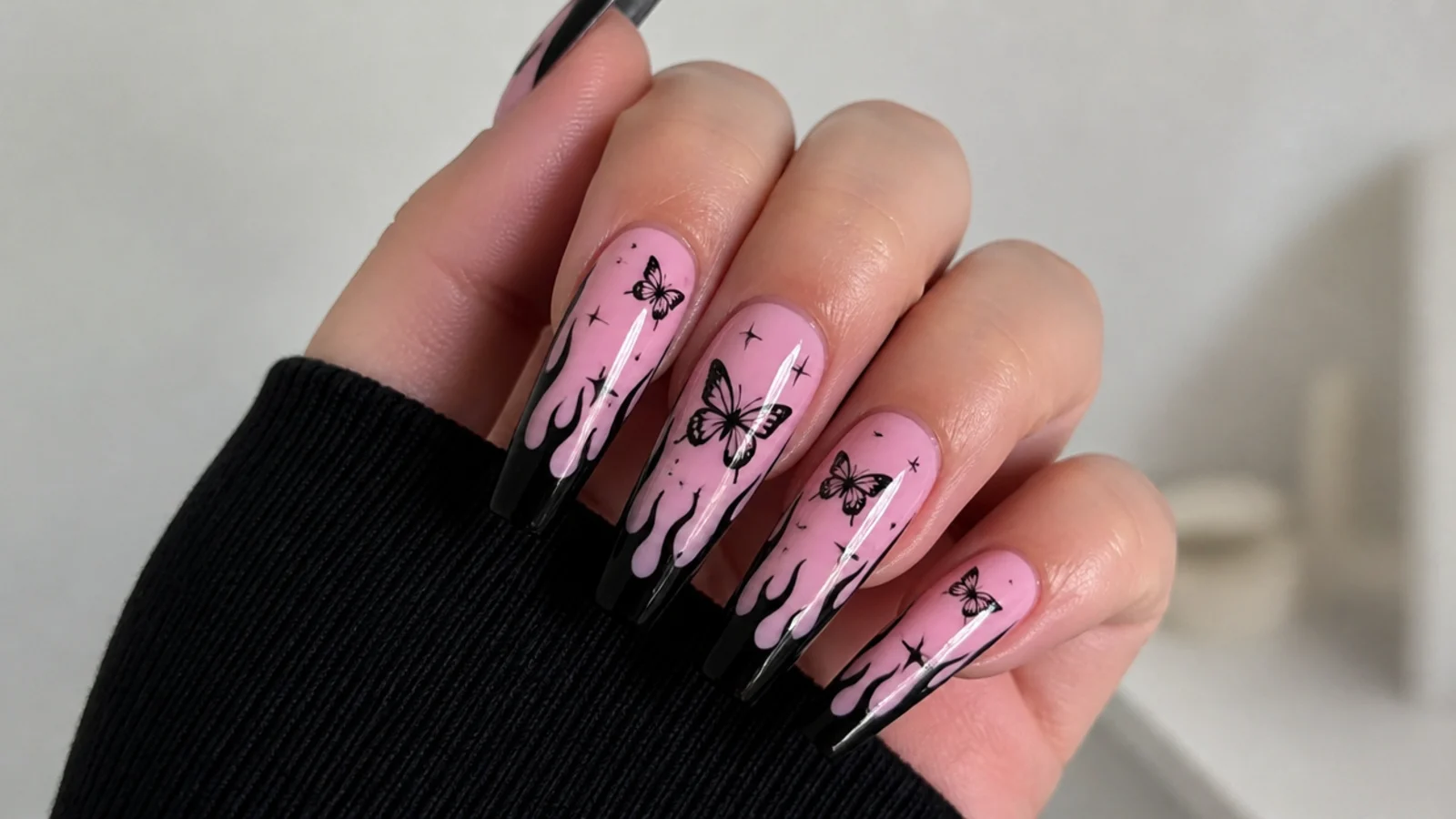 Pink nails with black butterfly accents, emo Y2K style