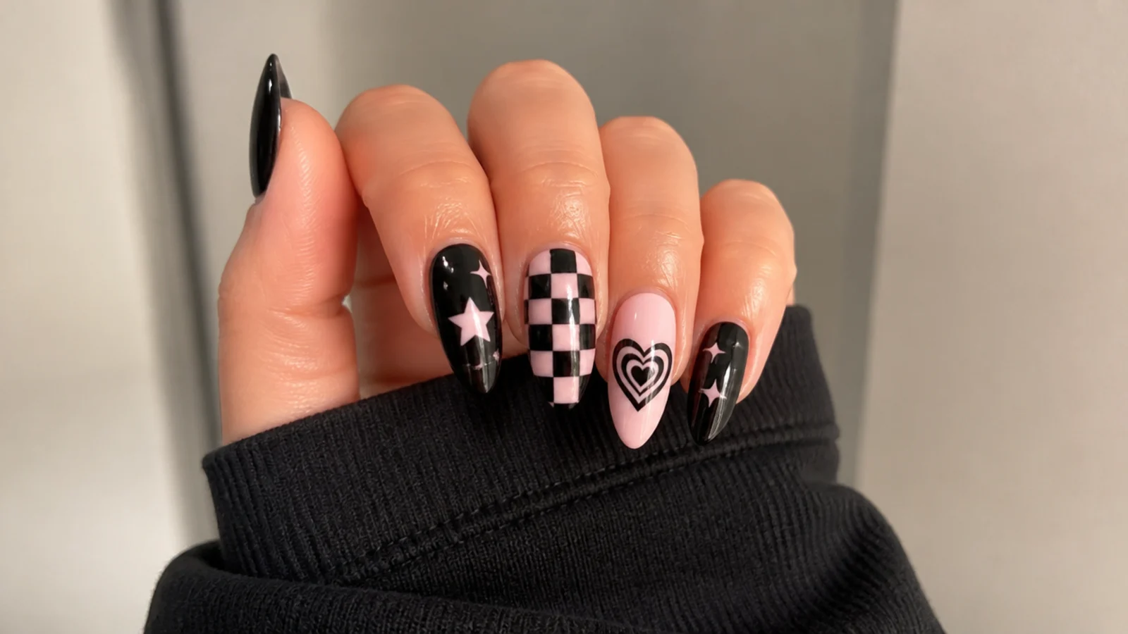Black nails with checkerboard, hearts and stars showing core emo motifs