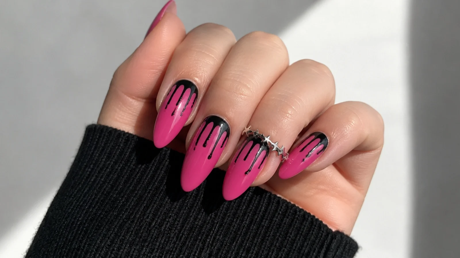 Pink emo nails with black paint drips running down from the cuticle
