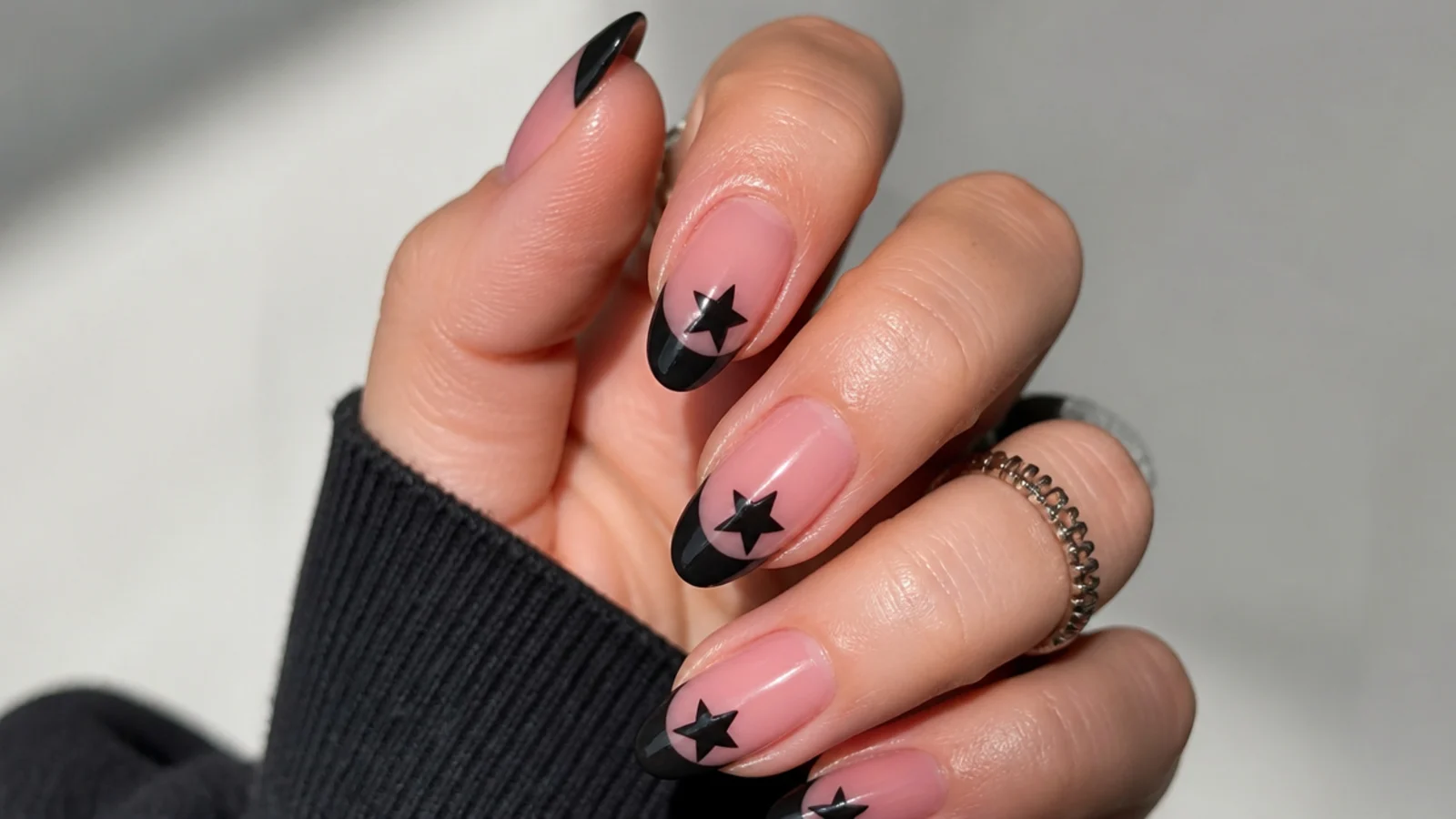 Pink emo nails with black star French tips on almond nails