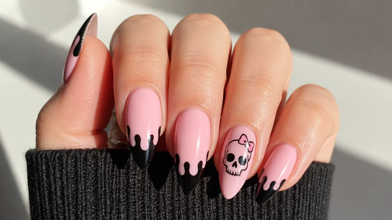 Pink emo nails with a small black skull on an accent nail