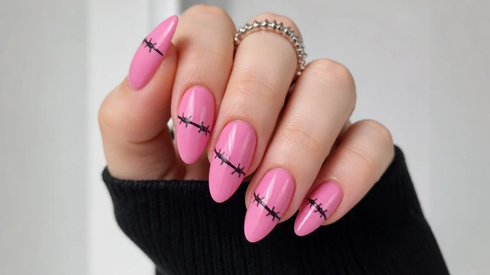Pink emo nails with a black barbed-wire line across each nail