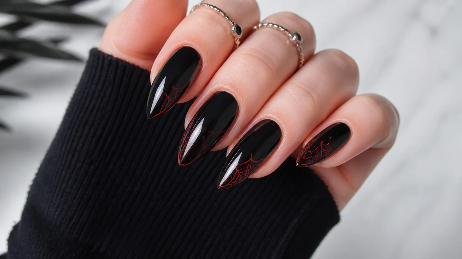 Black emo nails with fine red spiderwebs in the corners