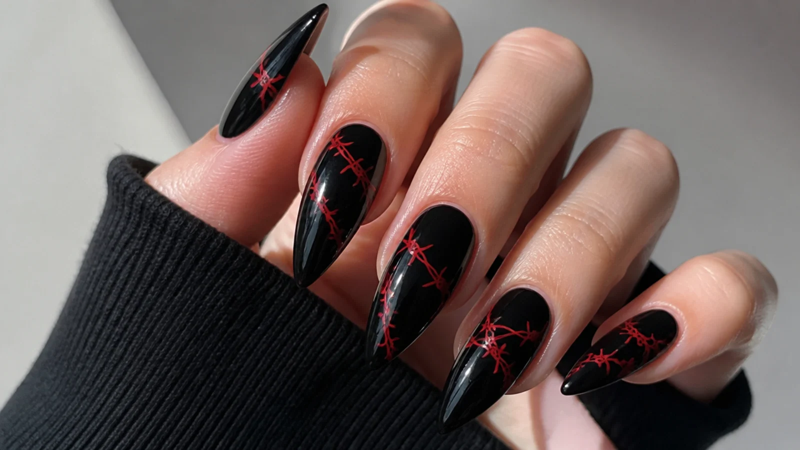 Black emo nails with red barbed wire wrapping across the nail
