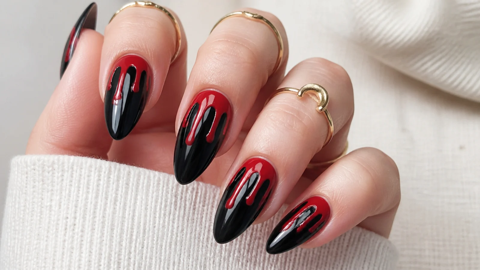 Black nails with glossy red drip melting down from the cuticle