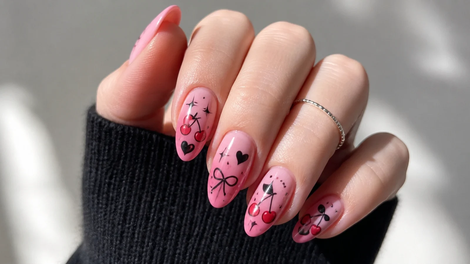 Pink nails with black and red cherry motifs in Y2K emo style