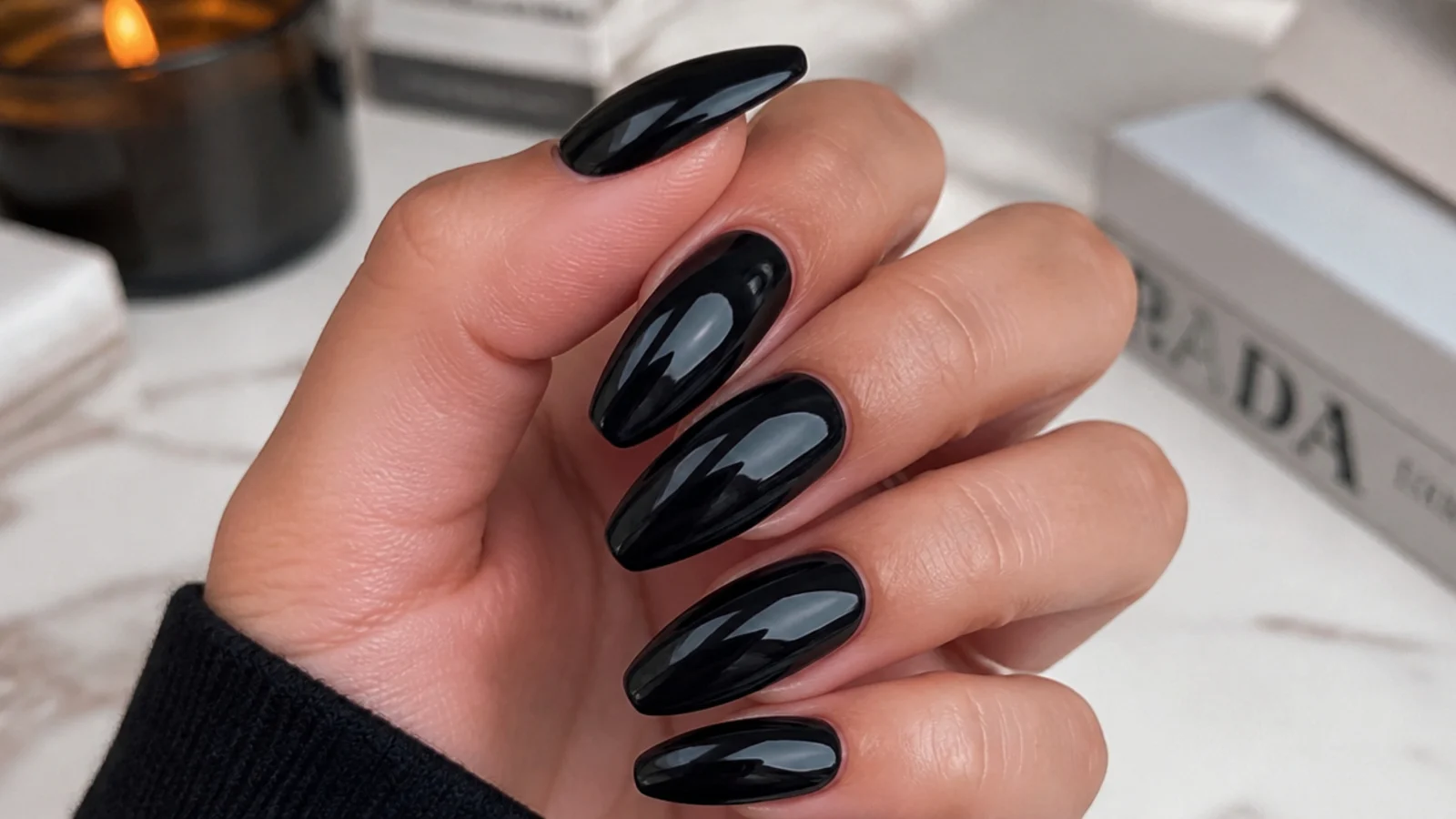 Glossy solid black almond nails with a wet high-shine finish