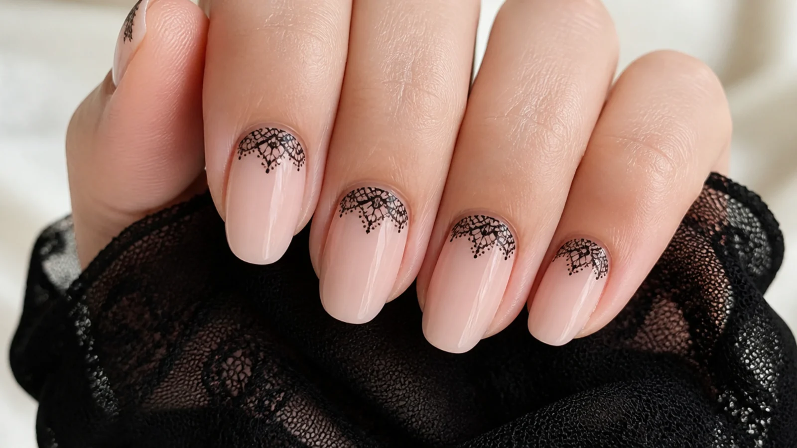 Sheer nails with delicate black lace pattern near the cuticle