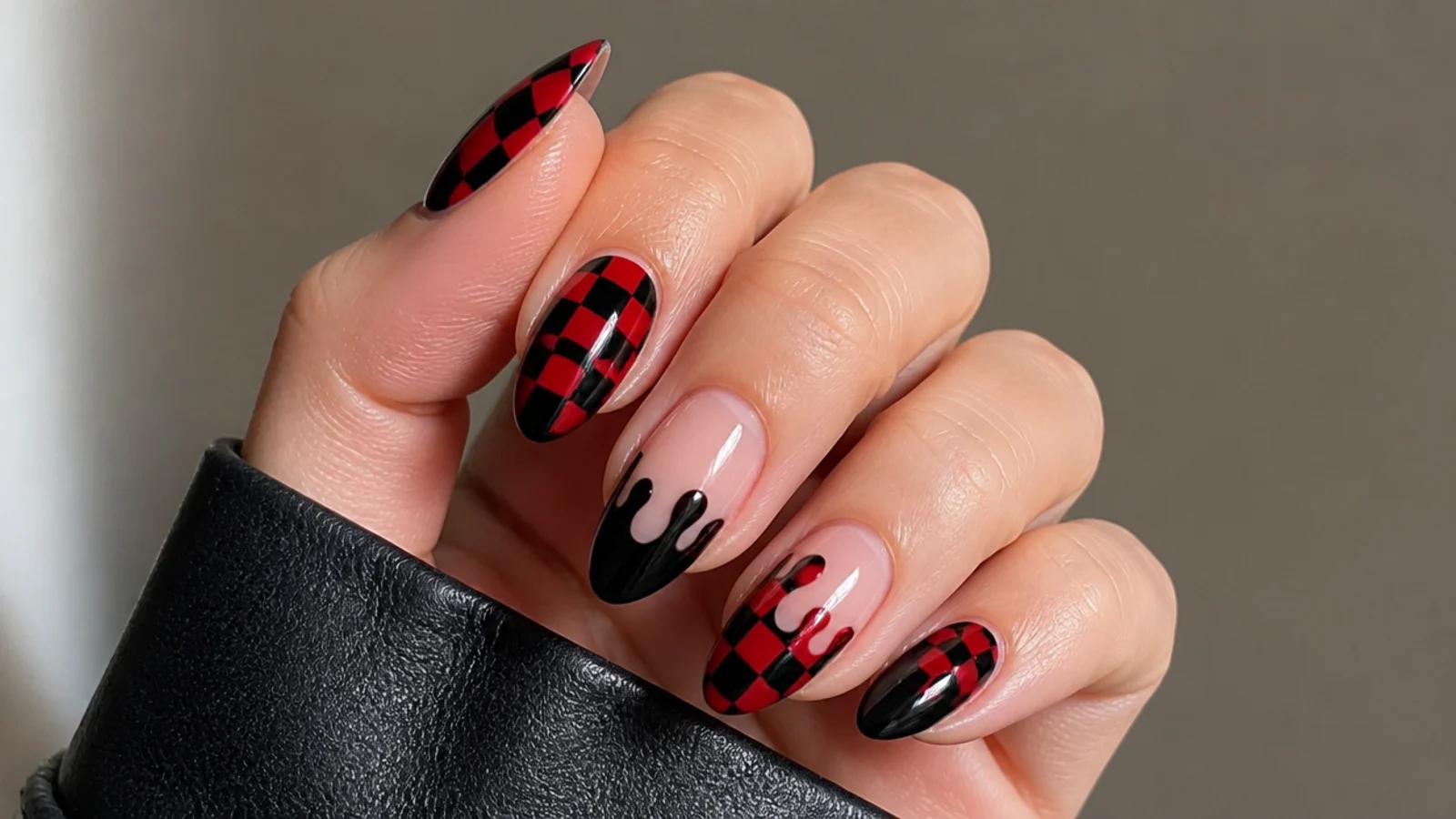 Nails combining red-black checkerboard with a glossy black drip