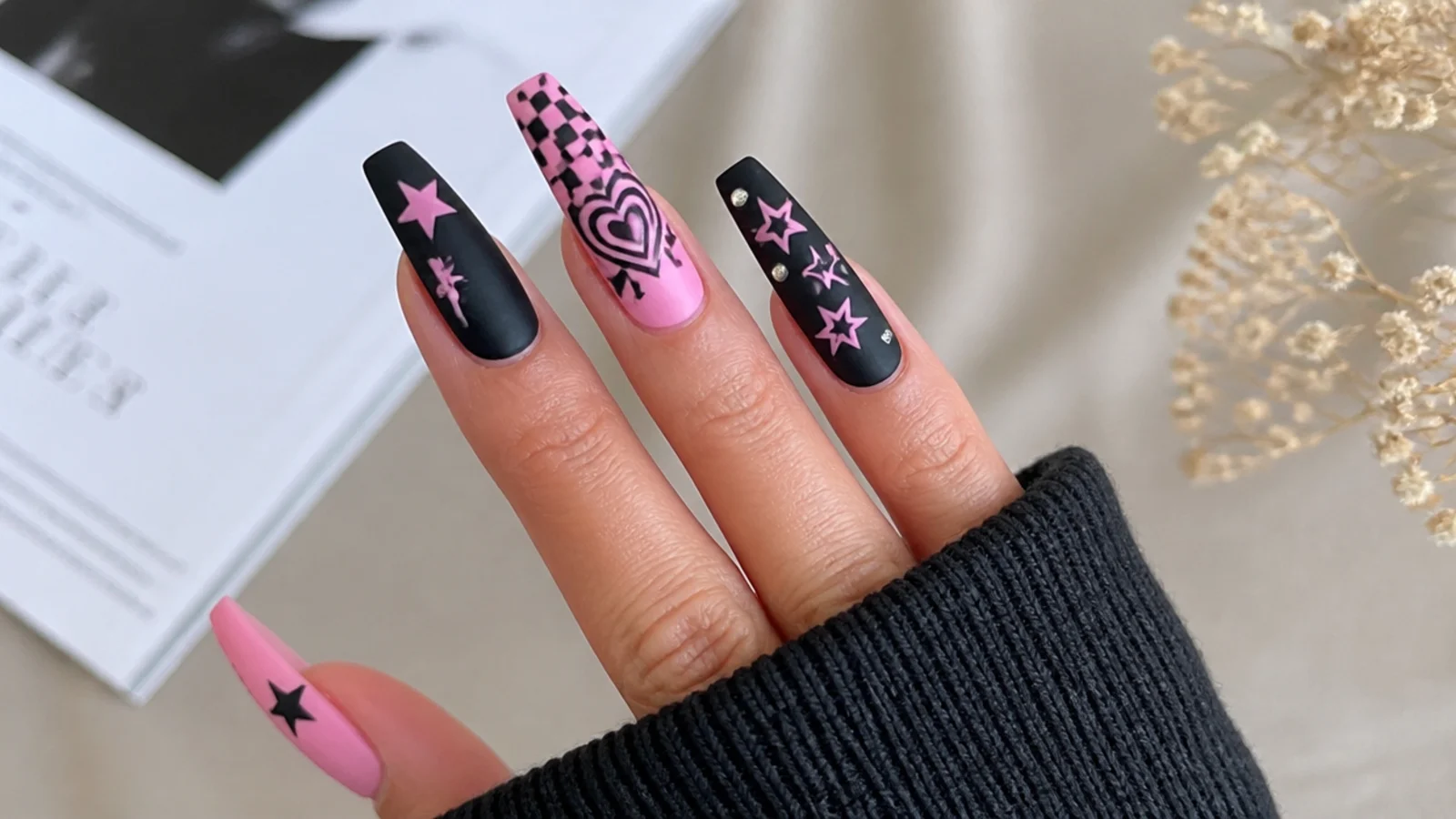 Black and pink scene emo nails with checkerboard, hearts and stars on a coffin shape