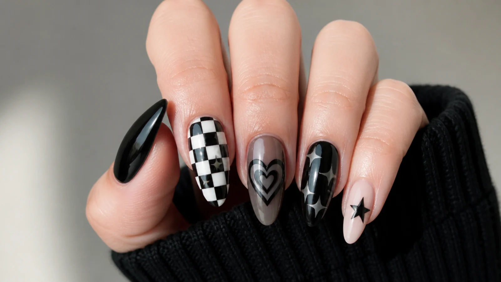 Black nails with checkerboard, hearts and stars showing core emo motifs