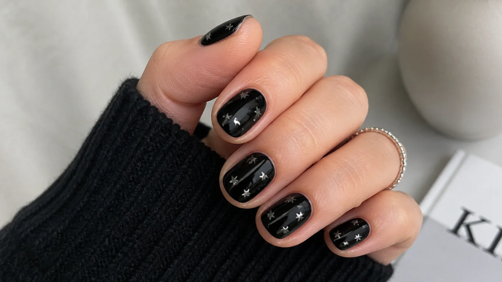Short black nails with tiny silver five-point stars scattered across