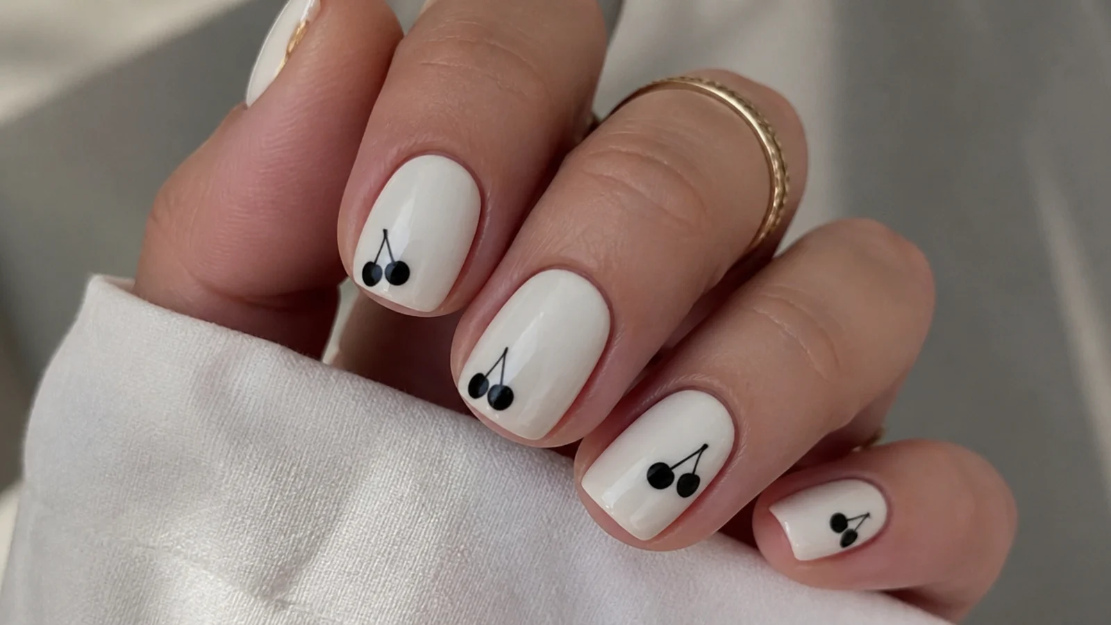 Short white nails with small black cherries and stems