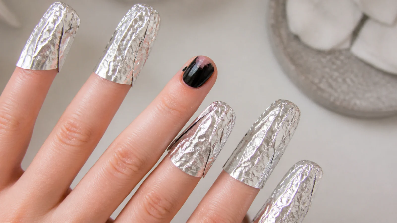 Short black emo nails soaking off in acetone-soaked cotton and foil