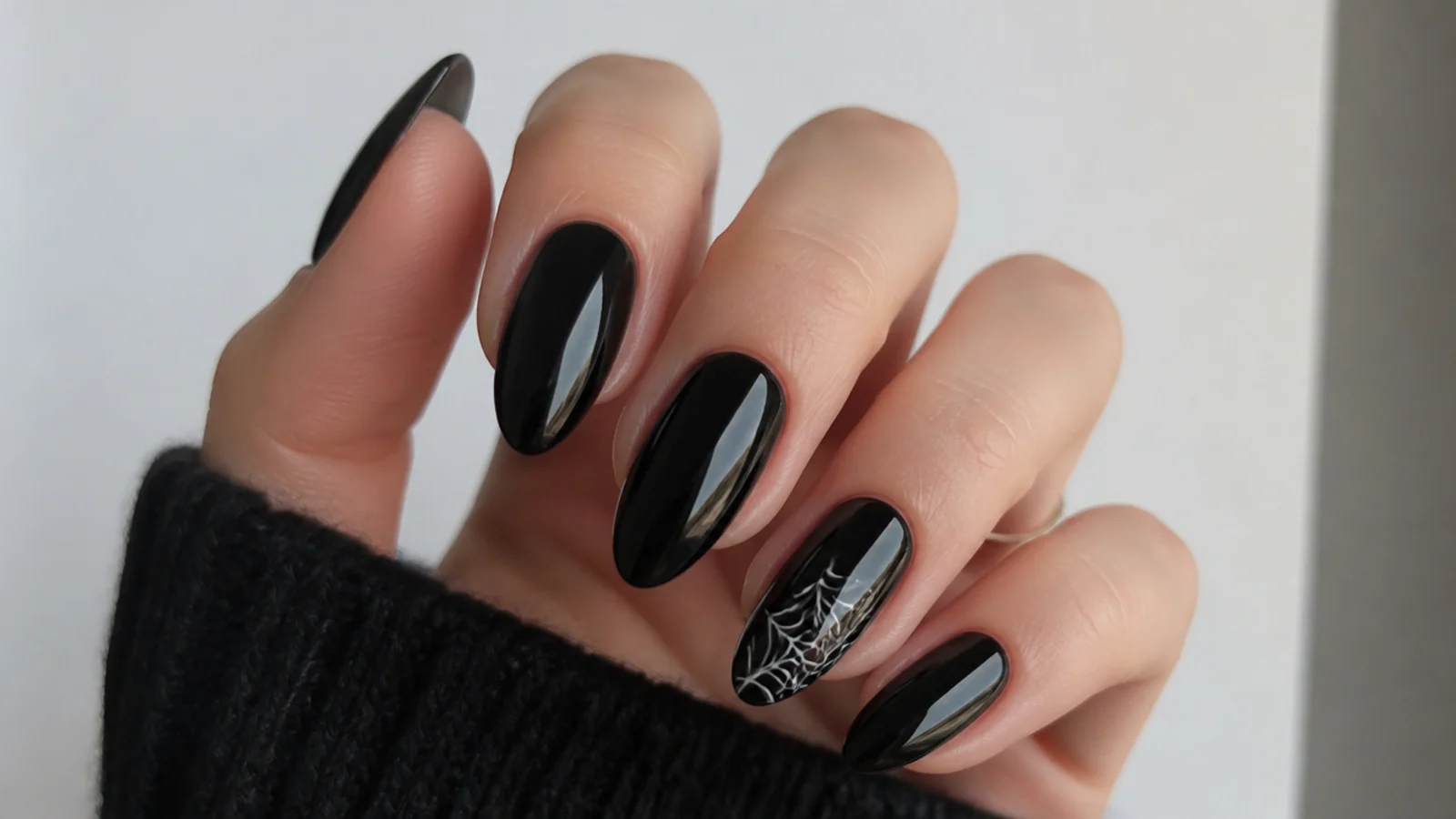 Black emo nails with a thin white spiderweb in one corner