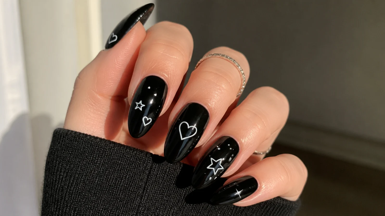 Black emo nails with a mix of small white stars and hearts