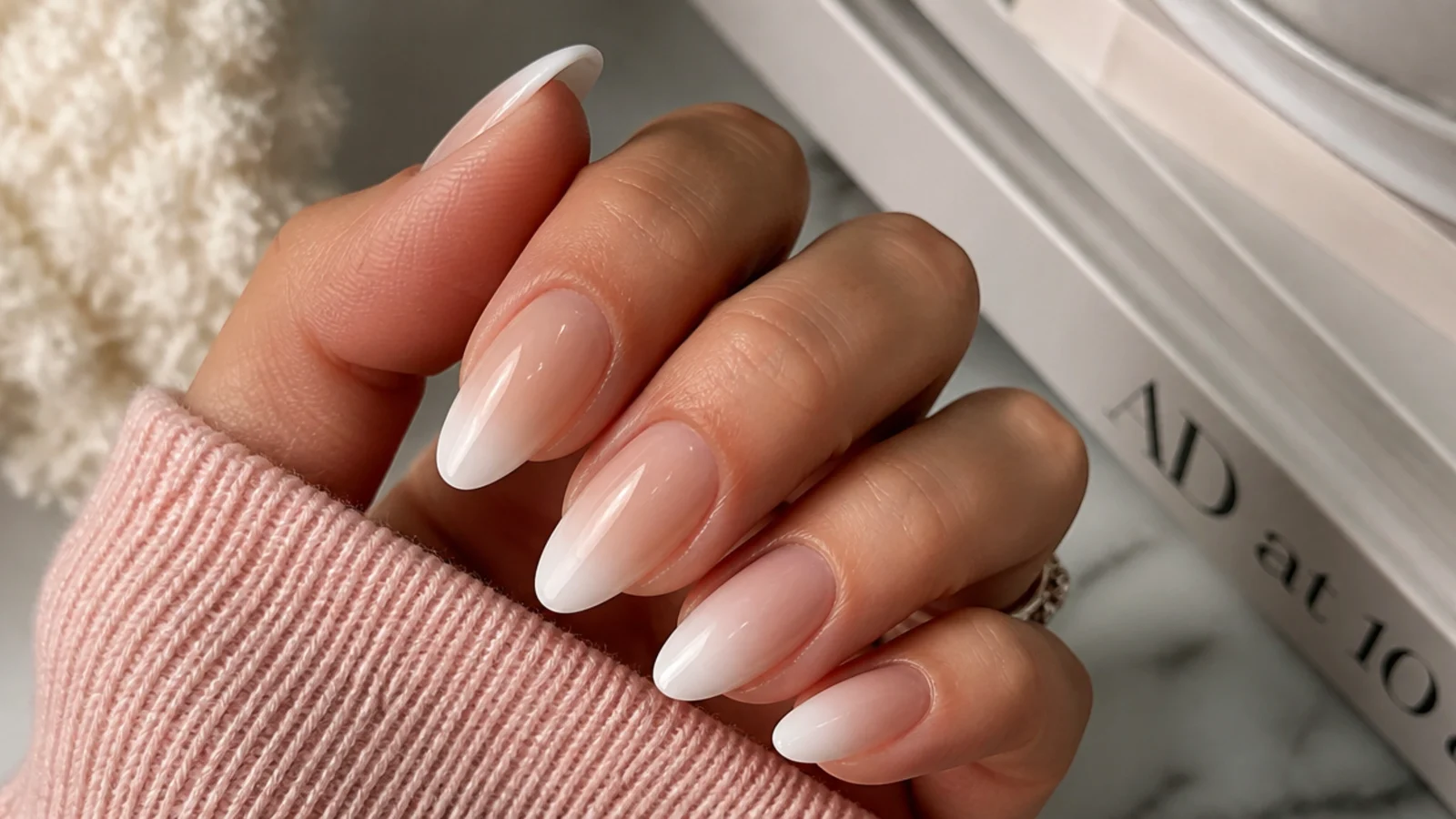 Almond nails with a white ombre French tip blending softly into a sheer nude base