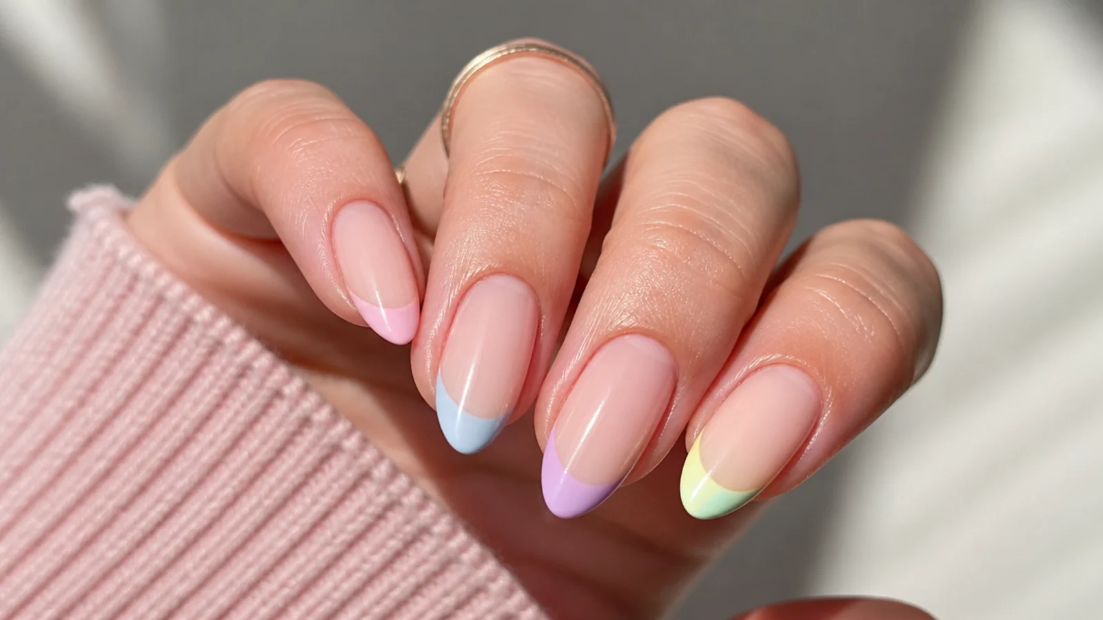 Almond nails with each tip painted a different pastel color on a sheer nude base