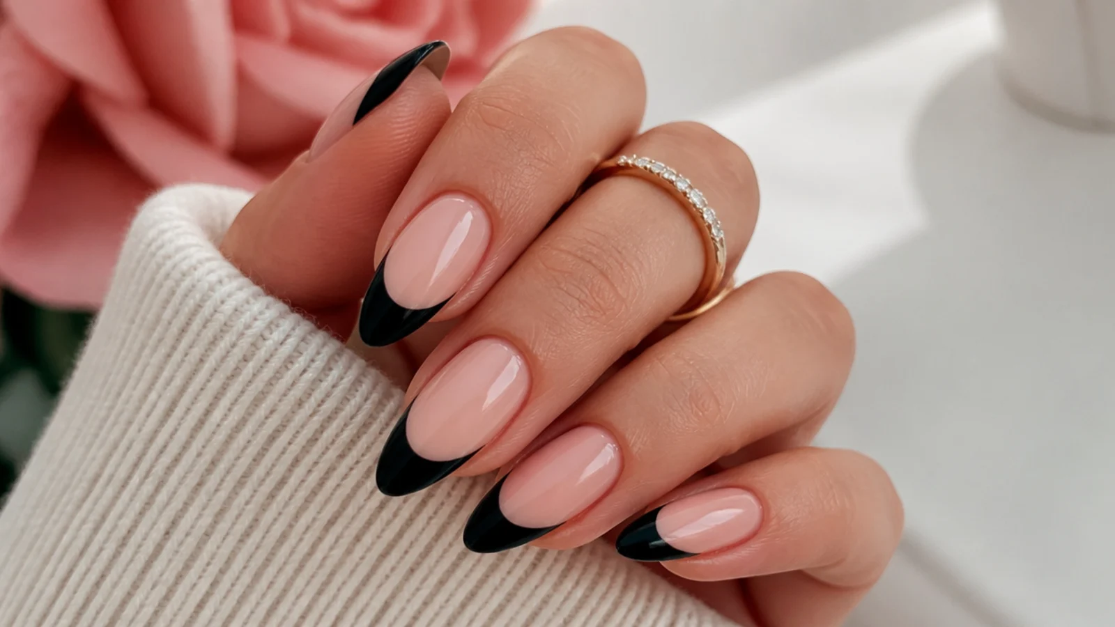 Long almond nails with black French tips following the taper toward a soft rounded point