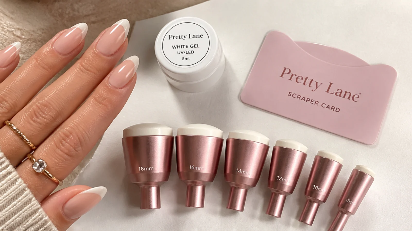 Six French tip stamper heads in graduated widths arranged next to a scraper card and white gel