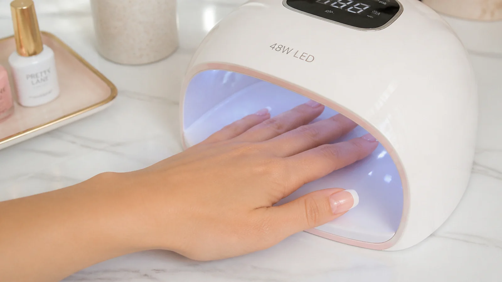 Hand curing white gel French tips under a compact 48 watt LED nail lamp